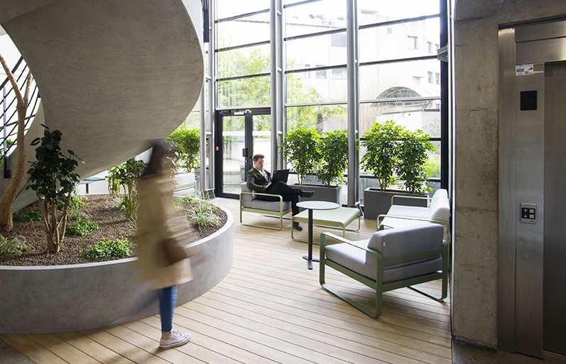 hall d'accueil d'une entreprise avec une grande verrière et des plantes